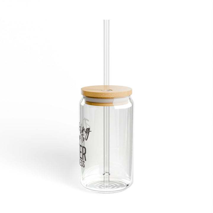 A clear tempered glass sipper with a bamboo lid and a plastic straw, featuring text that reads &