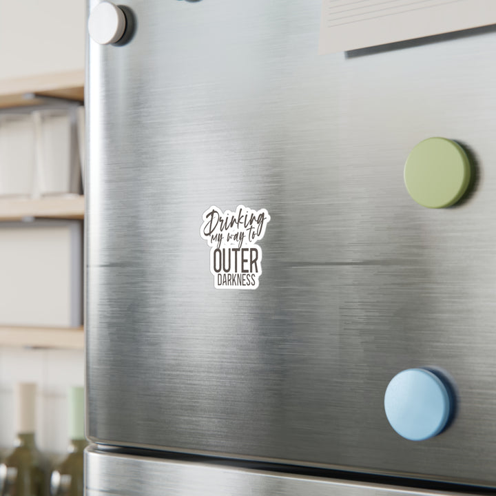 A white vinyl sticker with a black text and design, placed on a refrigerator.
