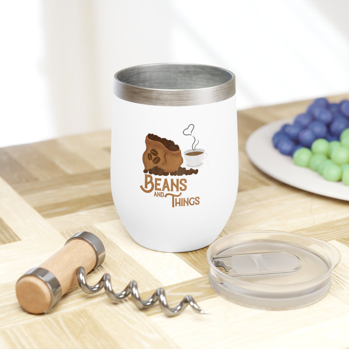 A white stainless steel tumbler with a clear, BPA-free press-on lid featuring a coffee-themed graphic that reads &