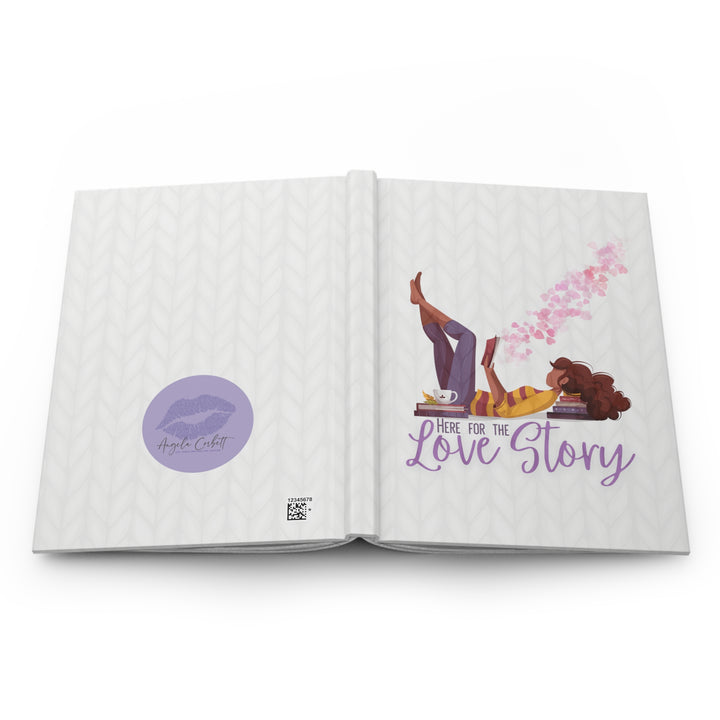 A hardcover journal with a white cover featuring a cartoon illustration of a woman reading a book, with the title &