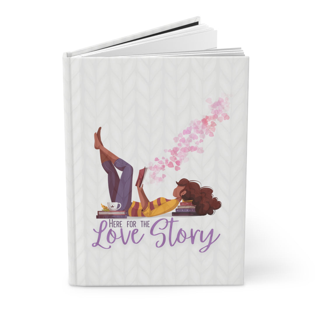 A hardcover journal with a white cover featuring a cartoon illustration of a woman reading a book, with the title 'Here For The Love Story'.