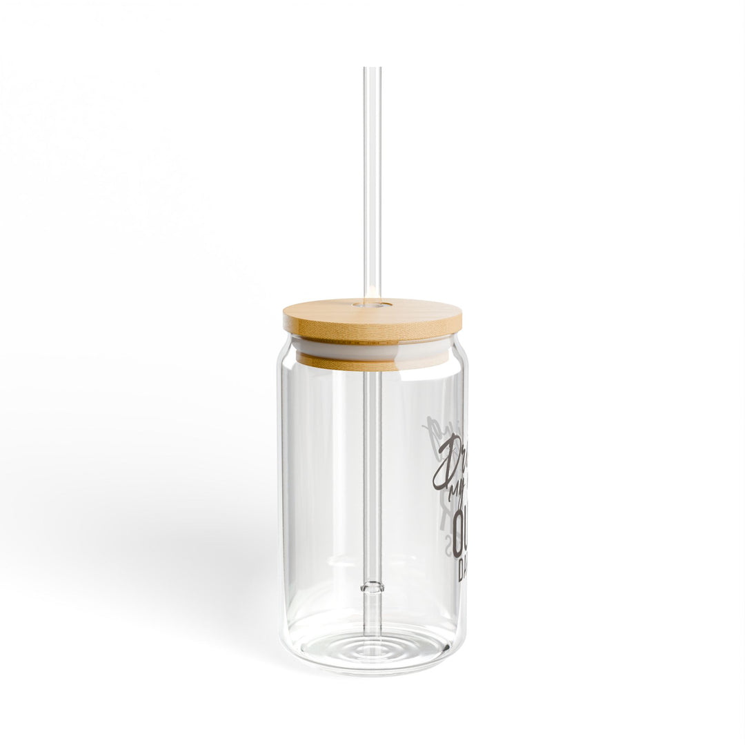 A clear tempered glass sipper with a bamboo lid and a plastic straw, featuring text that reads &
