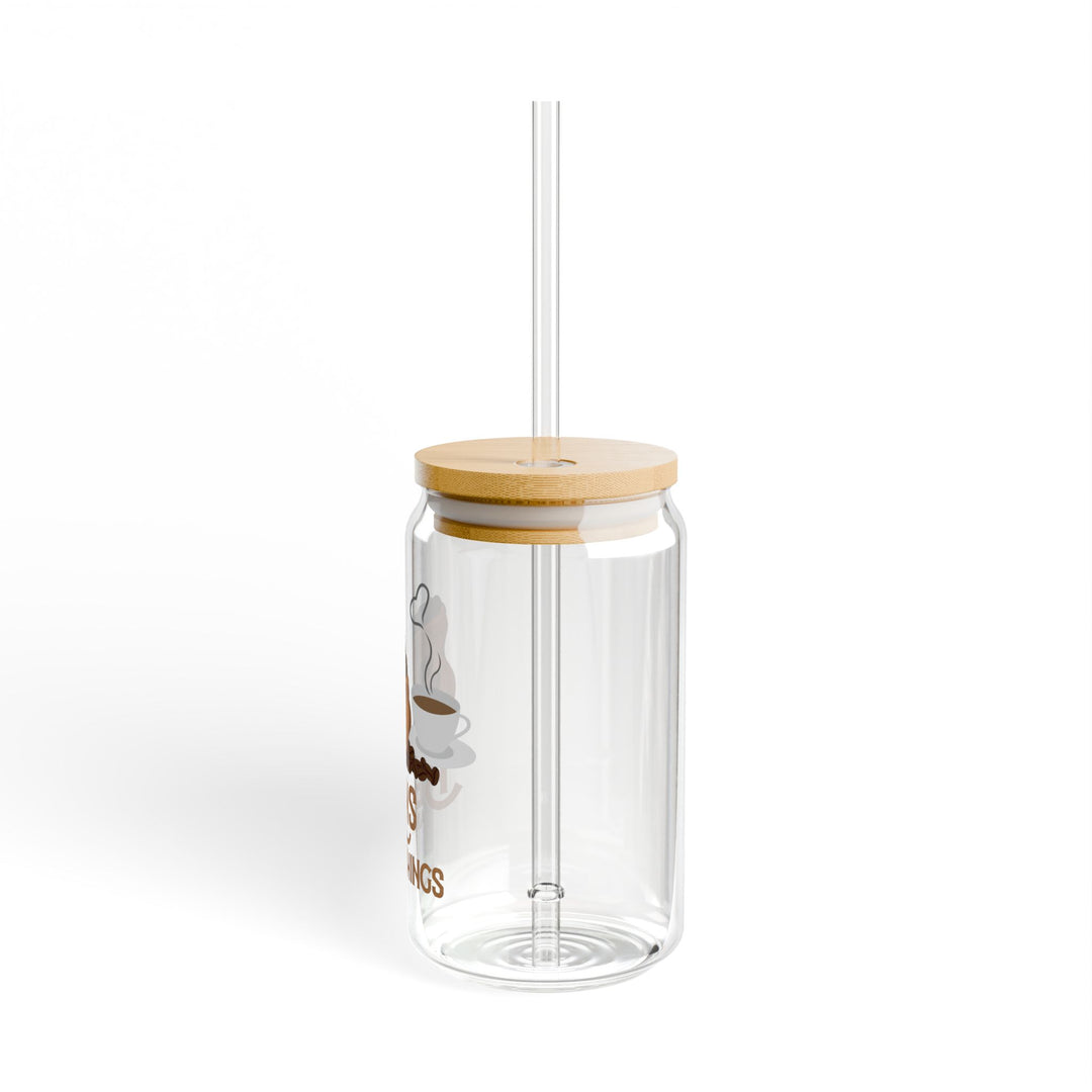 A clear tempered glass sipper with a bamboo lid and a plastic straw, featuring printed text &