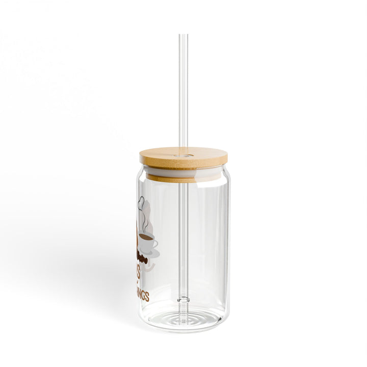 A clear tempered glass sipper with a bamboo lid and a plastic straw, featuring printed text &