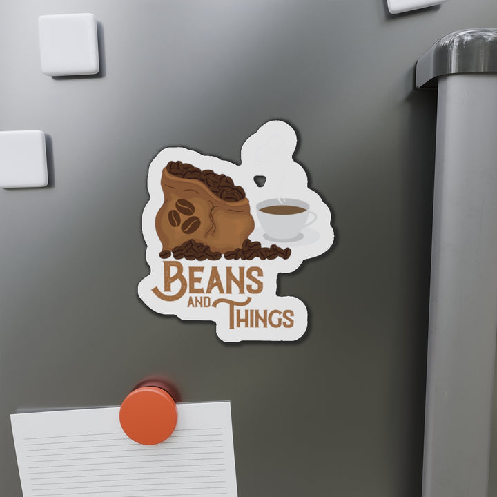 A magnet with an illustration of a coffee cup and beans, with the text &