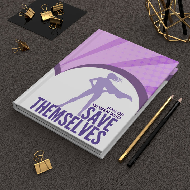A journal with a purple and white cover featuring a silhouette of a woman superhero and the text &