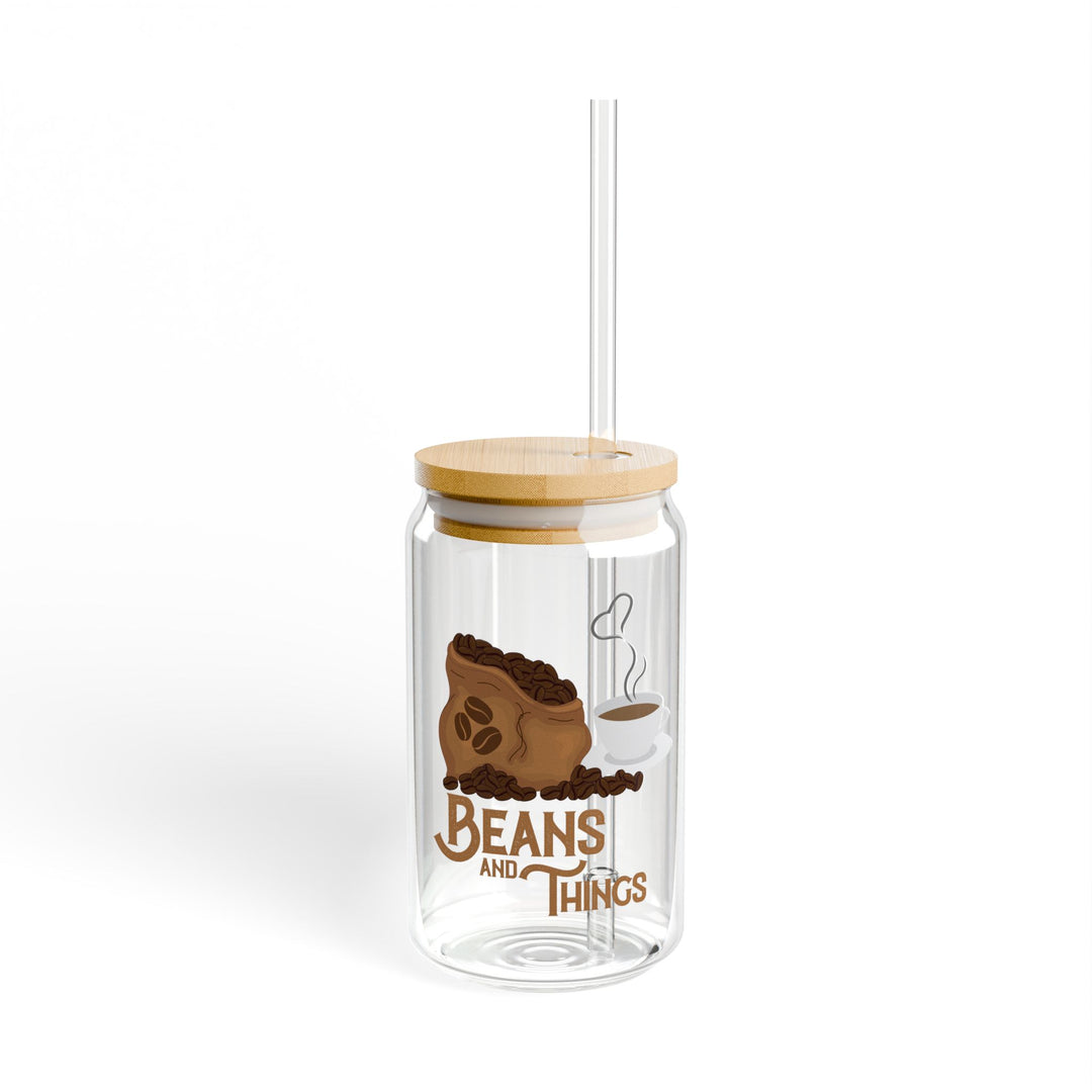 A clear tempered glass sipper with a bamboo lid and a plastic straw, featuring printed text &