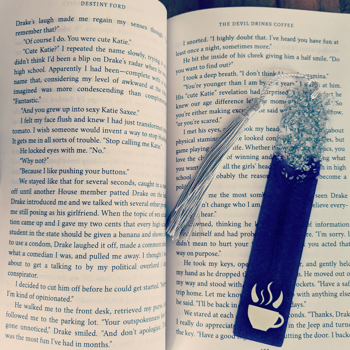 A purple bookmark inside of the book "The Devil Drinks Coffee"